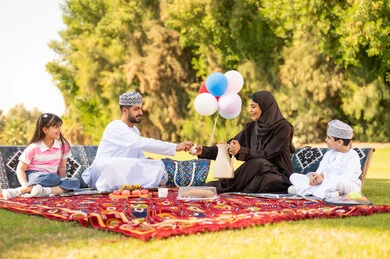 نزهة عائلة عمانية في الحديقة باللباس التقليدي