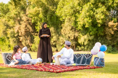 عائلة عُمانية في نزهة بالحديقة بالزي التقليدي