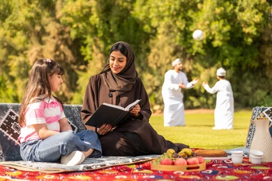 نزهة عائلية عمانية مع أم تقرأ في الحديقة