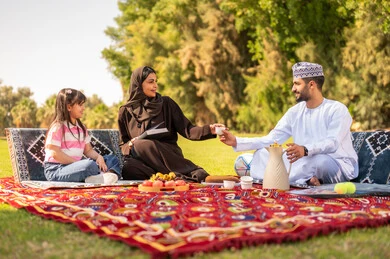 Omani Family Picnic in Park with Traditional Clothing