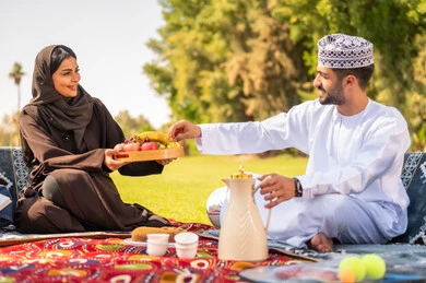 رجل عماني وامرأة خليجية في نزهة في الحديقة