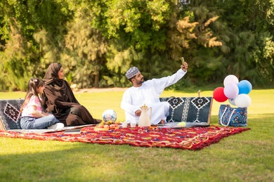 عائلة عمانية في نزهة بالحديقة تلتقط سيلفي