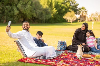 عائلة سعودية في نزهة بالحديقة يلتقطون سيلفي