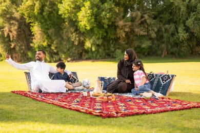 عائلة سعودية في نزهة بالحديقة يلتقطون سيلفي