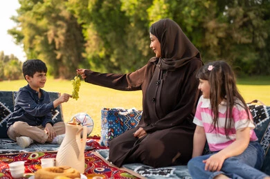 Saudi Mother and Children Having a Picnic in Park