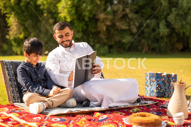 Arab Father Reading Book to Son in Park Picnic
