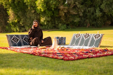 امرأة سعودية بالعباءة في نزهة بالحديقة