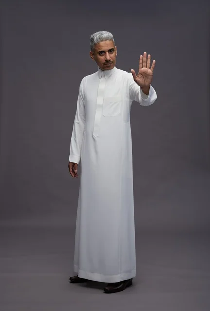 رجل سعودي بالثوب التقليدي مع إيماءة التوقف