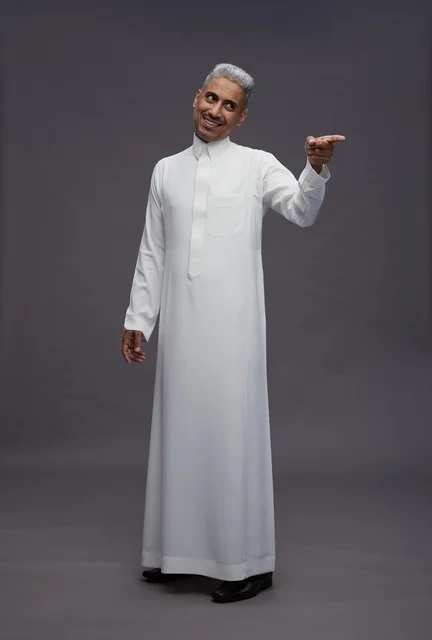 Saudi Man in White Thobe Pointing on Grey Background