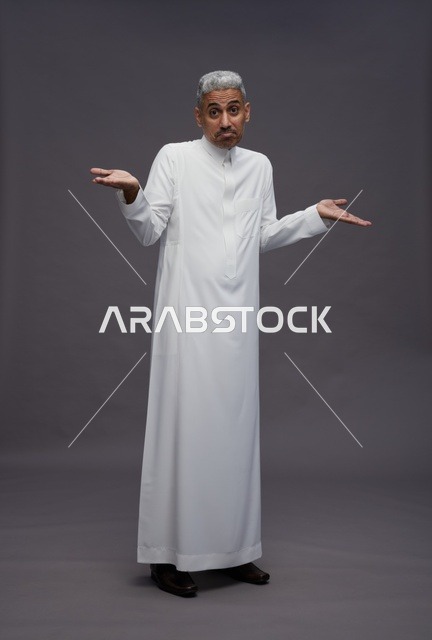 رجل سعودي بالثوب الأبيض يرفع يديه بحيرة