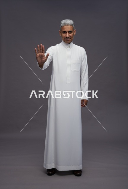 رجل سعودي بالثوب التقليدي يقوم بإيماءة التوقف