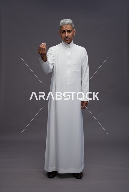 رجل سعودي بالثوب التقليدي يقوم بإيماءة باليد