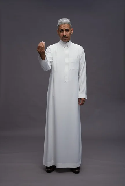 رجل سعودي بالثوب التقليدي يقوم بإيماءة باليد