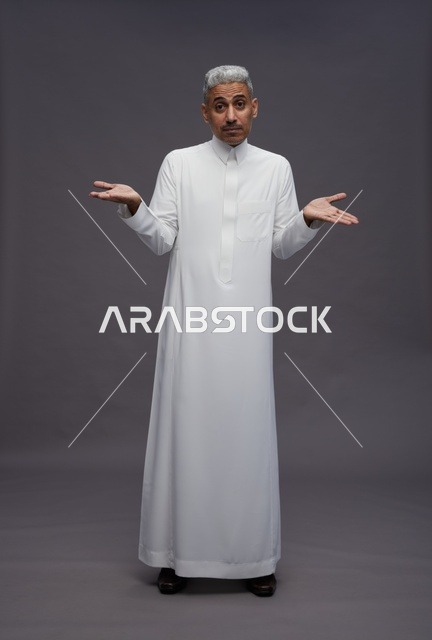 رجل سعودي بالثوب الأبيض يرفع يديه بحيرة