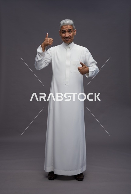 رجل سعودي بالثوب الأبيض يشير بعلامة الإعجاب
