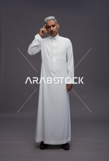 رجل سعودي بالثوب الأبيض يشير إلى رأسه