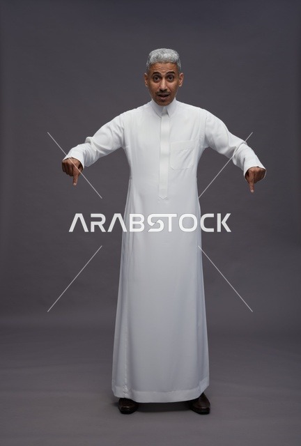 Saudi Man in Thobe Pointing Down with Surprised Face