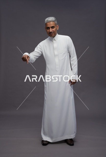 Saudi Man in White Thobe Pointing Down on Gray