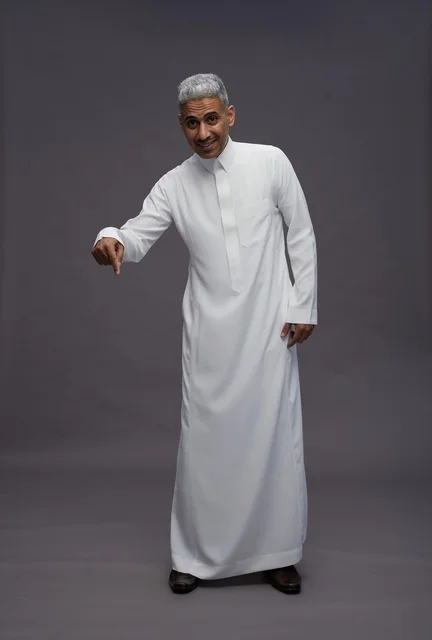 رجل سعودي يرتدي الثوب التقليدي الأبيض يشير للأسفل
