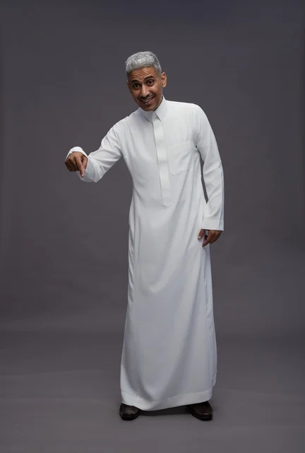 رجل سعودي بالثوب الأبيض يشير للأسفل خلفية رمادية