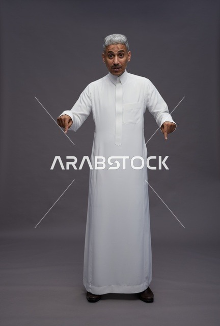 Saudi Man in White Thobe Pointing Down with Shocked Expression