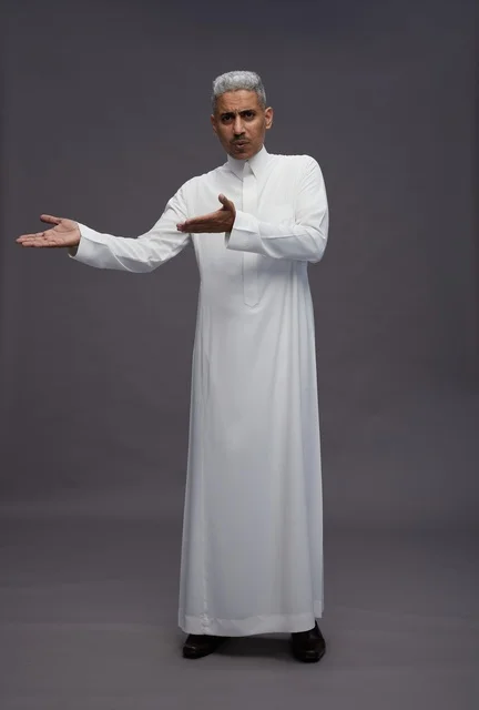 Saudi Man in White Thobe Gesturing on Grey Background