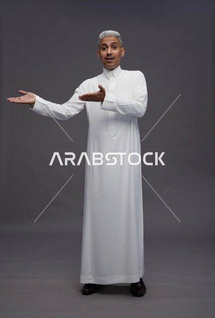 Saudi Man in Traditional Thobe Pointing on Grey Background