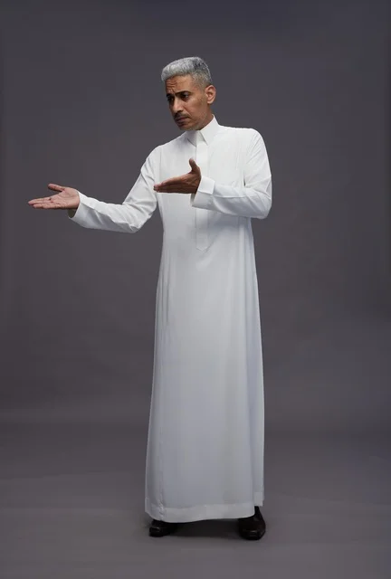 Saudi Man in White Thobe Gesturing on Grey Background