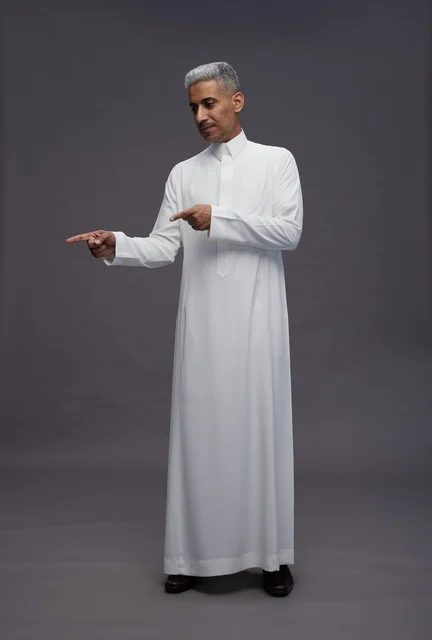 Saudi Man in White Thobe Pointing on Grey Background