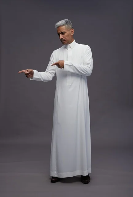 Saudi Man in White Thobe Pointing on Grey Background