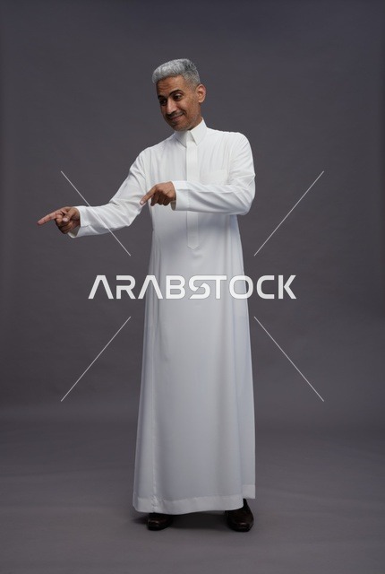 Saudi Man in White Thobe Pointing on Grey Background