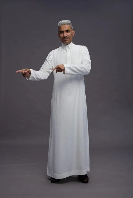 Saudi Man in White Thobe Pointing on Grey Background
