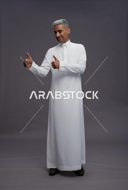 رجل سعودي يرتدي ثوبًا أبيض ويتفاعل مع الكاميرا