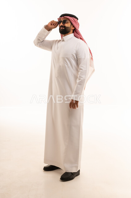 Saudi Man in Traditional Thobe Adjusting Sunglasses