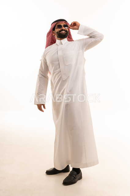 رجل سعودي بالثوب التقليدي يرتدي نظارة شمسية