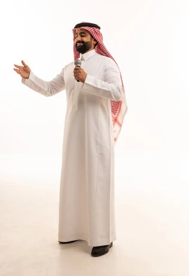 رجل سعودي يغني بالميكروفون في الاستوديو