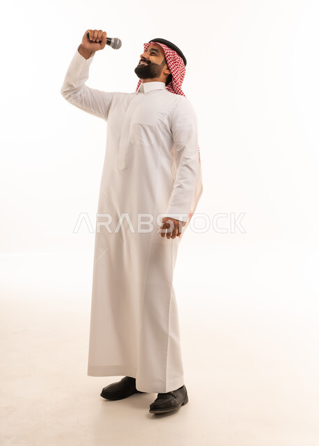 رجل سعودي بالزي التقليدي يغني مع ميكروفون
