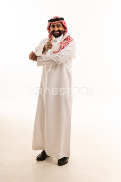 رجل سعودي بالزي التقليدي يقوم بإيماءة يد إيجابية