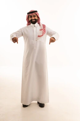 Smiling Saudi Man in Traditional Thobe Pointing Down