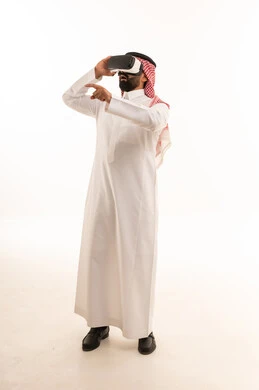 Saudi Man Using VR Headset in Traditional Dress