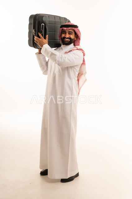 رجل سعودي بالزي التقليدي يحمل حقيبة سفر
