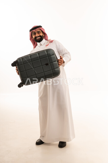 رجل سعودي يحمل حقيبة سفر سوداء في الاستوديو