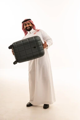 رجل سعودي يحمل حقيبة سفر سوداء في الاستوديو