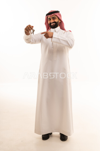 Saudi Man Holding House Keys on White Background