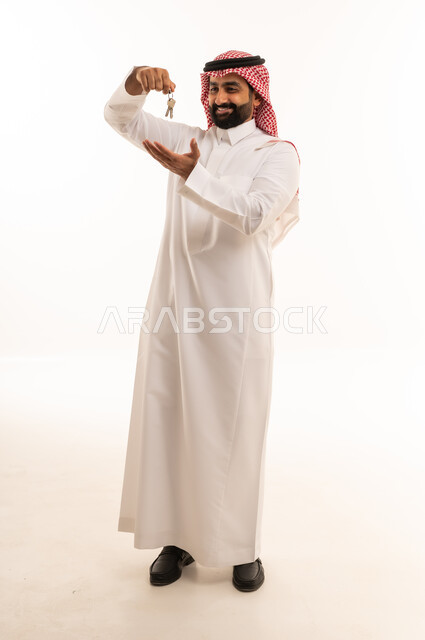 رجل سعودي بالزي التقليدي يحمل مفاتيح
