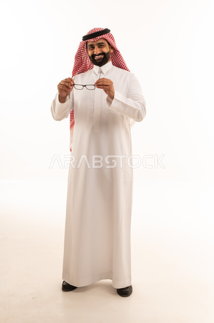 رجل سعودي بالزي التقليدي يمسك نظارة طبية