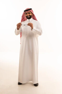 رجل سعودي بالزي التقليدي يمسك نظارة طبية