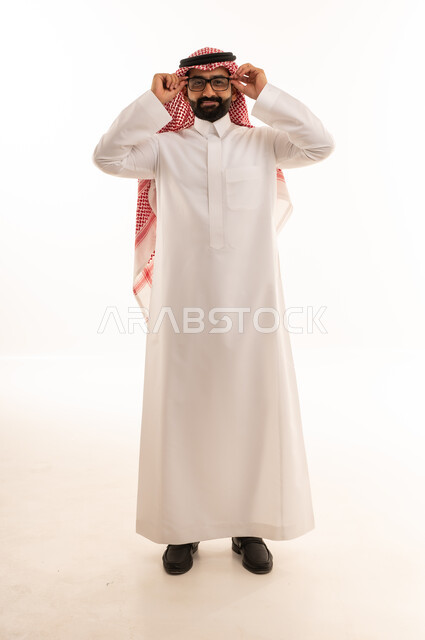 رجل سعودي بالثوب التقليدي يضبط نظارته الطبية