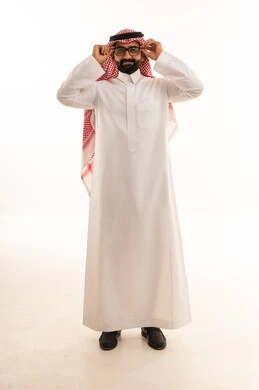 رجل سعودي بالثوب التقليدي يضبط نظارته الطبية