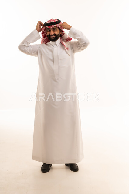 رجل سعودي بالثوب التقليدي يعدل العقال